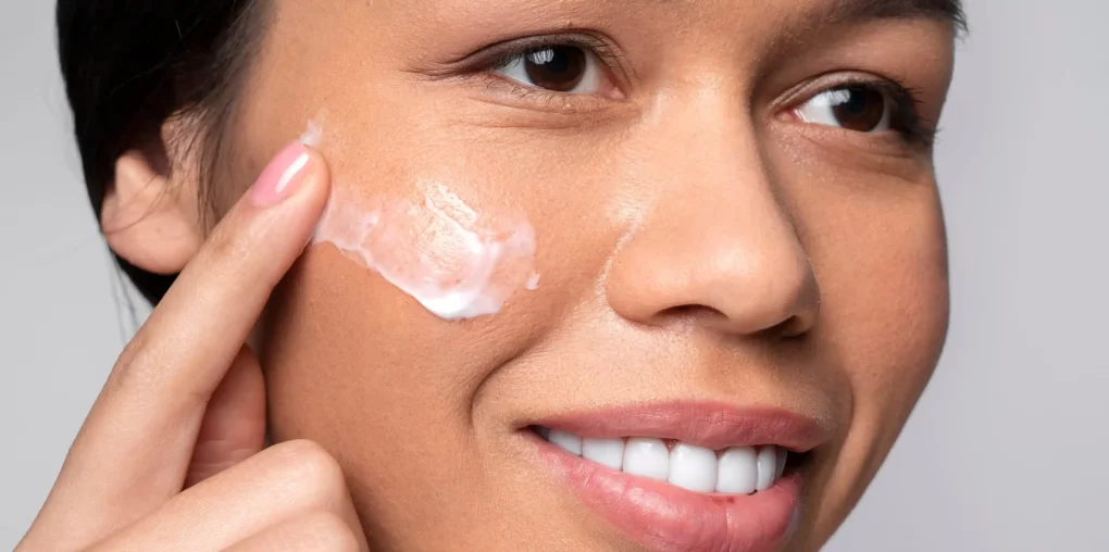 Woman applying skincare cream for dark spots on face
